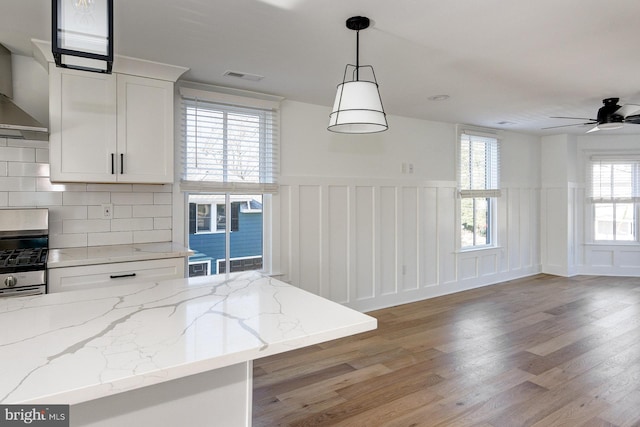 kitchen with white cabinets, decorative light fixtures, a healthy amount of sunlight, and light hardwood / wood-style flooring