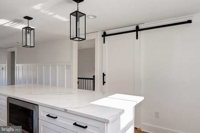 kitchen featuring white cabinets, wine cooler, and decorative light fixtures