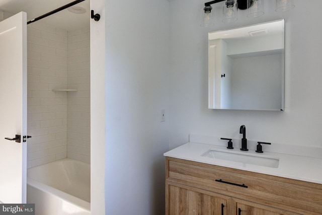 bathroom with tiled shower / bath combo and vanity