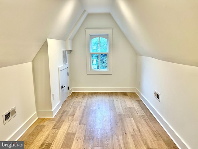 bonus room with light hardwood / wood-style floors and vaulted ceiling