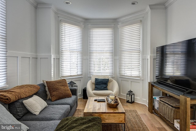 living room with plenty of natural light, light wood-type flooring, and crown molding