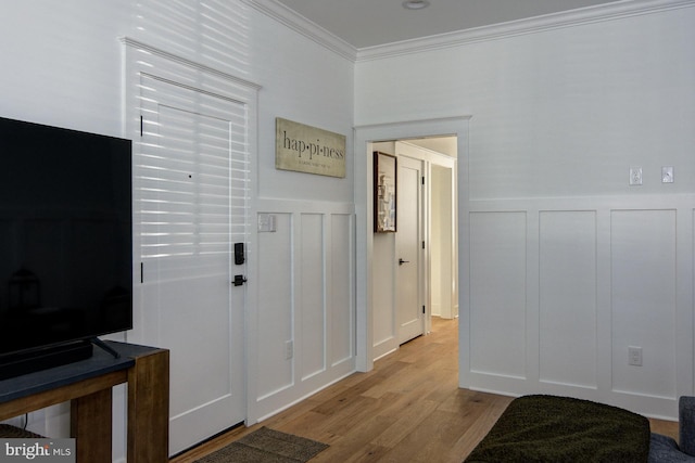 foyer featuring ornamental molding and light hardwood / wood-style flooring