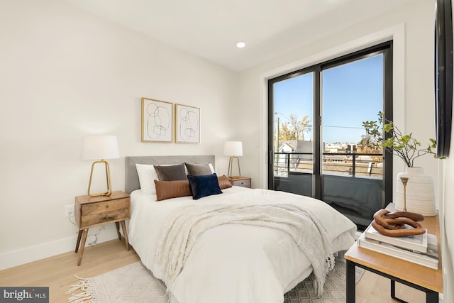 bedroom with light hardwood / wood-style flooring, access to outside, and multiple windows