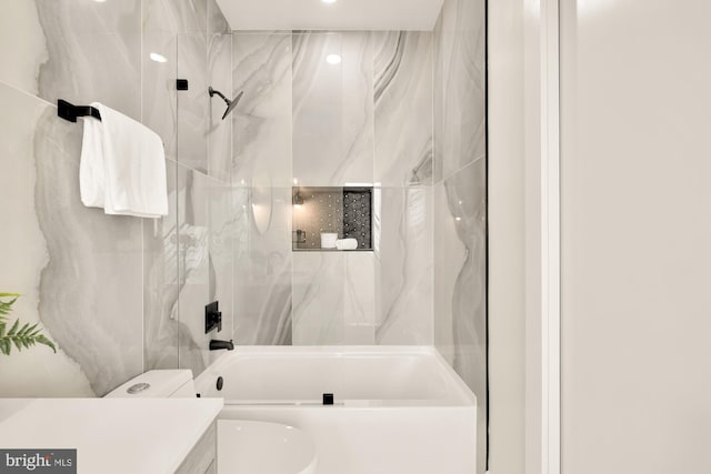 full bathroom with tiled shower / bath combo, toilet, and vanity