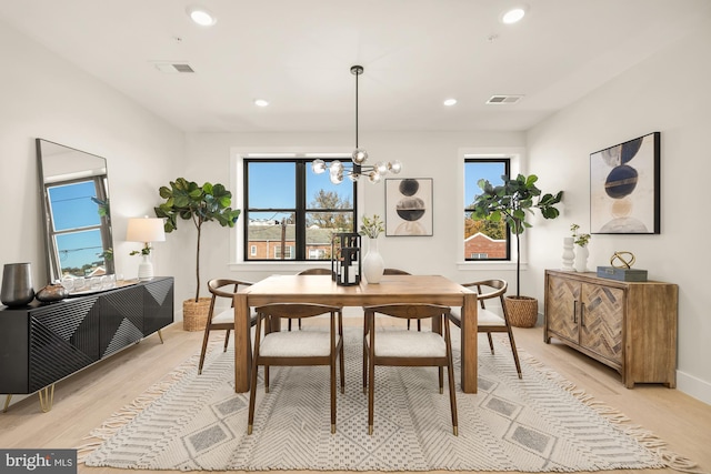 dining area with a chandelier and light hardwood / wood-style floors