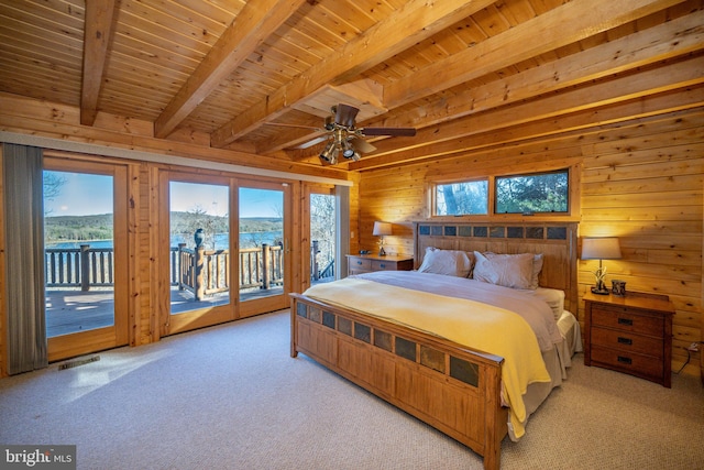 unfurnished bedroom with access to exterior, a water view, multiple windows, and light carpet