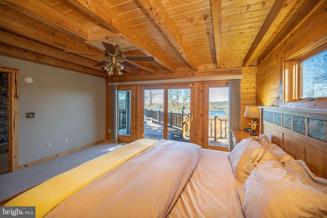 bedroom with a water view, access to exterior, wood walls, wooden ceiling, and beam ceiling