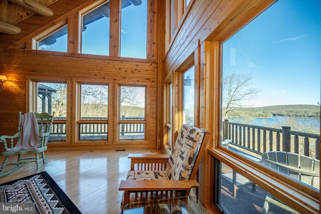 sunroom featuring lofted ceiling with beams and a water view