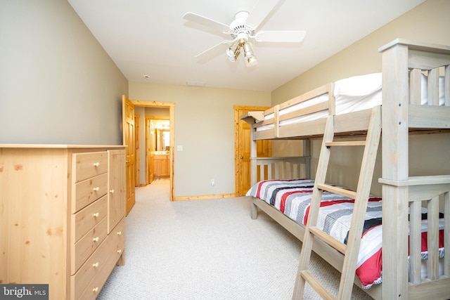 carpeted bedroom with ceiling fan and ensuite bath