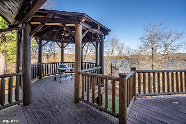 deck with ceiling fan, a gazebo, and a water view