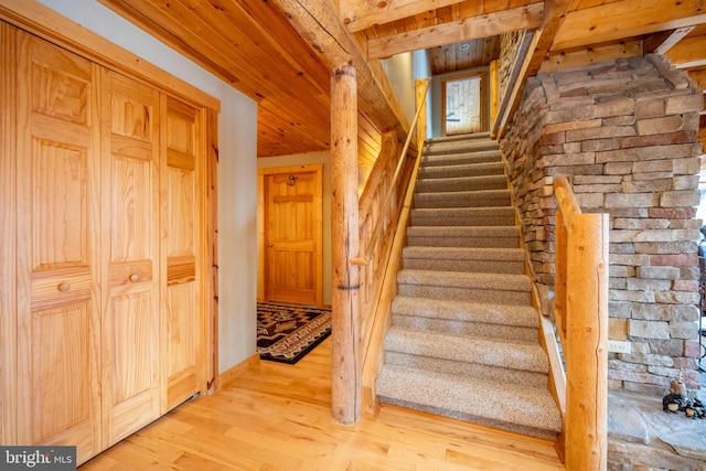 stairway with wood ceiling and hardwood / wood-style flooring