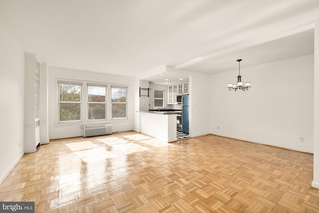 unfurnished living room with light parquet flooring and a chandelier