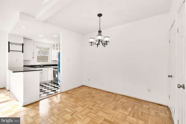 kitchen with sink, pendant lighting, stainless steel range oven, white cabinets, and light parquet flooring