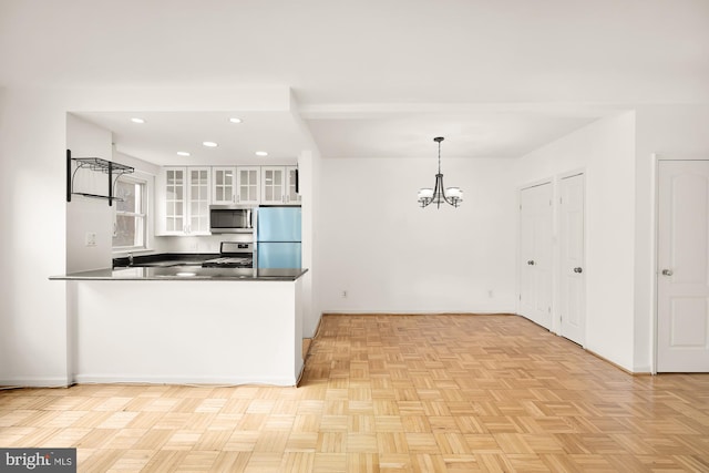 kitchen featuring appliances with stainless steel finishes, an inviting chandelier, white cabinets, light parquet flooring, and hanging light fixtures