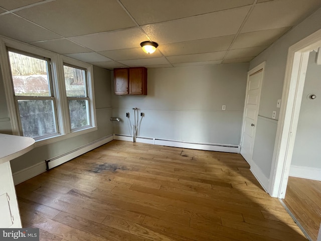 clothes washing area featuring light hardwood / wood-style floors and a baseboard heating unit