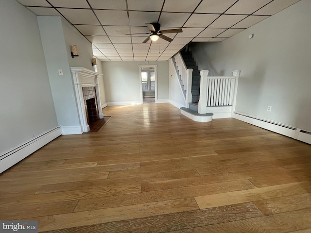 unfurnished living room with light hardwood / wood-style floors, a paneled ceiling, and ceiling fan