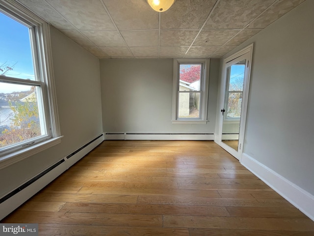 spare room featuring light wood-type flooring and a baseboard radiator