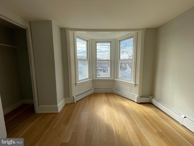 interior space with a baseboard radiator, a closet, and light hardwood / wood-style flooring