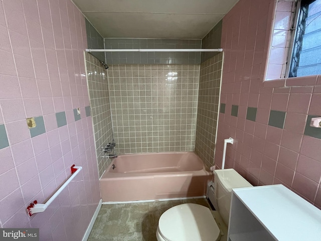 full bathroom with tile walls, vanity, toilet, and tiled shower / bath