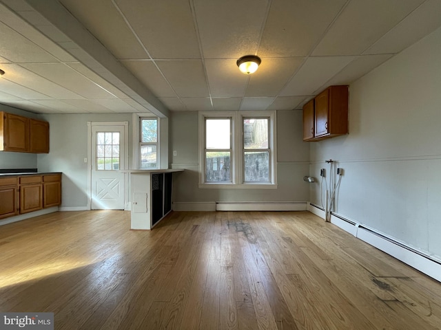 interior space featuring baseboard heating and light hardwood / wood-style flooring