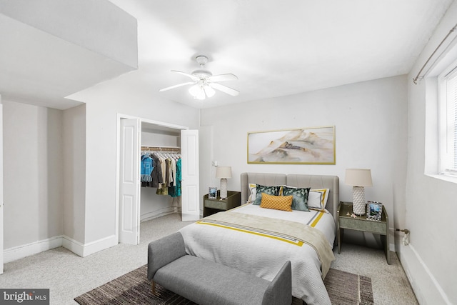 bedroom with ceiling fan, light carpet, and a closet