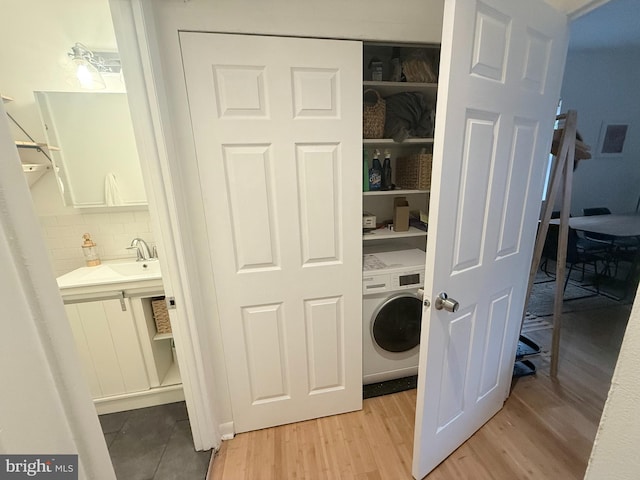 washroom with sink, light hardwood / wood-style flooring, and washer / clothes dryer