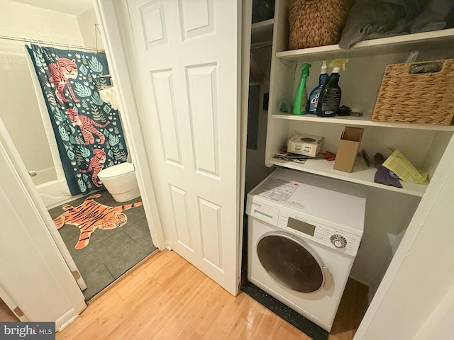 clothes washing area with light hardwood / wood-style floors and washer / dryer