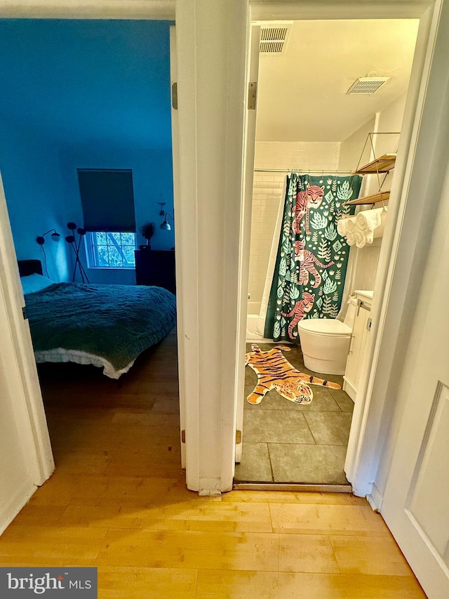 interior space with vanity, hardwood / wood-style flooring, toilet, and a shower with shower curtain