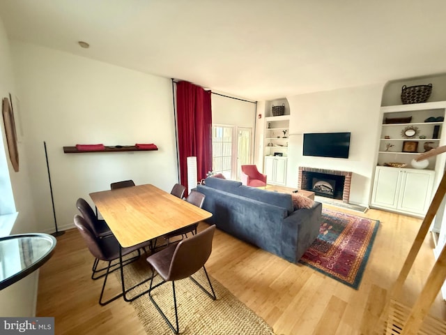 dining area with wood-type flooring and a fireplace