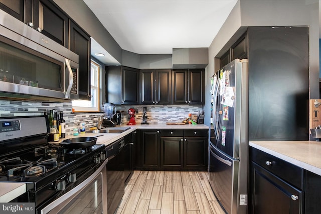 kitchen featuring backsplash, light hardwood / wood-style flooring, sink, and appliances with stainless steel finishes