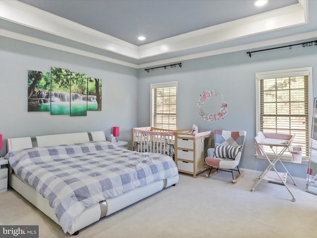 bedroom featuring ornamental molding, carpet, multiple windows, and a raised ceiling