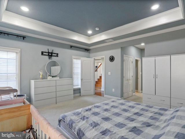 bedroom featuring light colored carpet, a raised ceiling, and crown molding