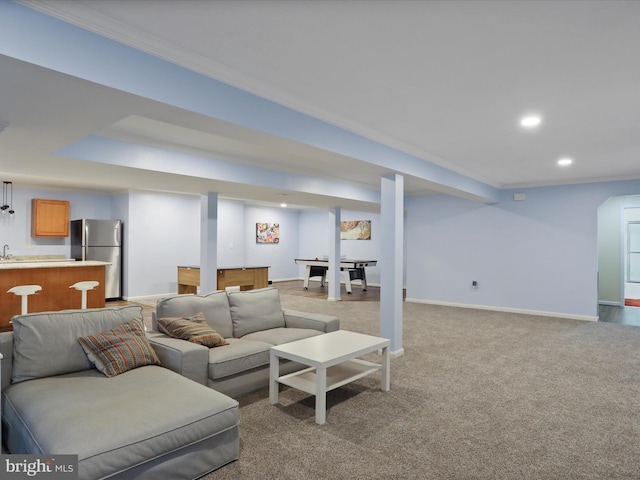 carpeted living room with bar area and crown molding