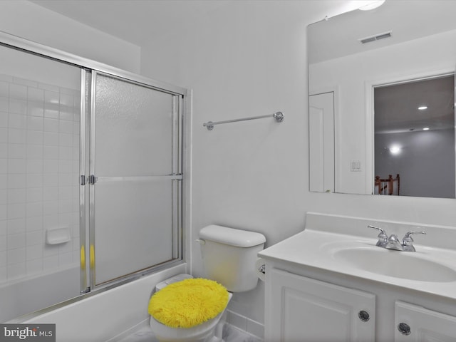 full bathroom featuring toilet, combined bath / shower with glass door, and vanity