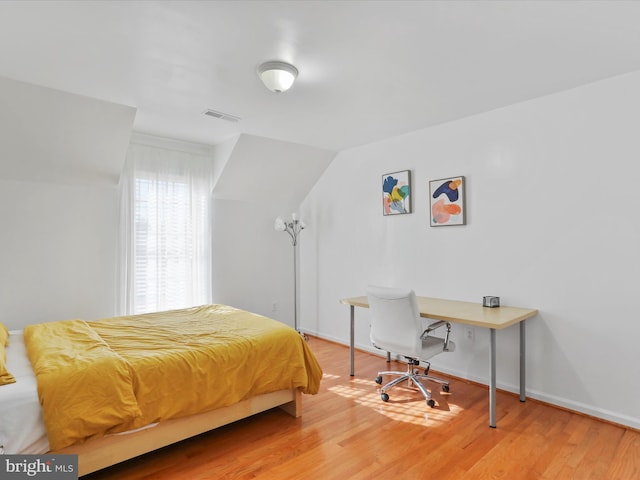 bedroom featuring hardwood / wood-style floors and vaulted ceiling