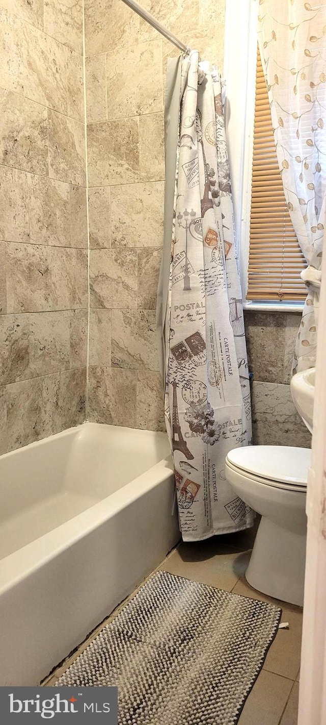 bathroom featuring toilet, shower / tub combo, and tile patterned flooring