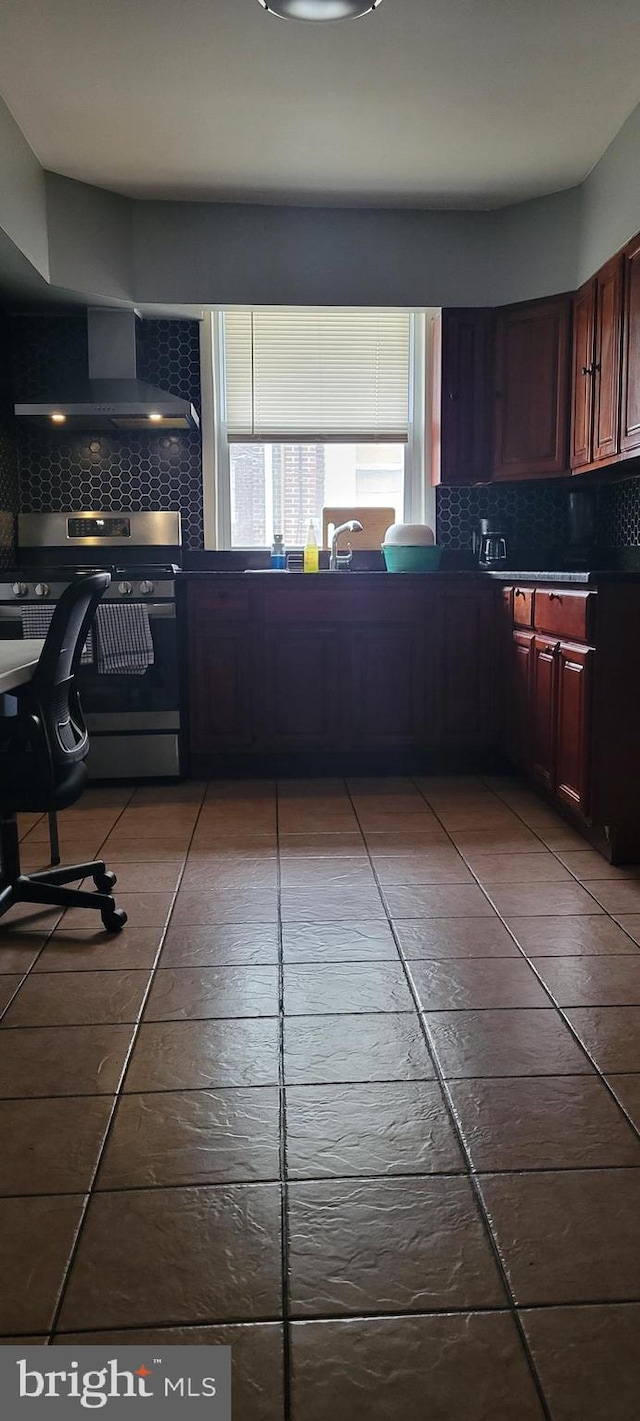 kitchen with backsplash, wall chimney range hood, and stainless steel range with electric cooktop