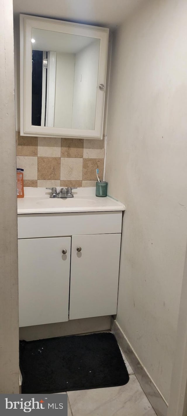 bathroom featuring vanity and tasteful backsplash