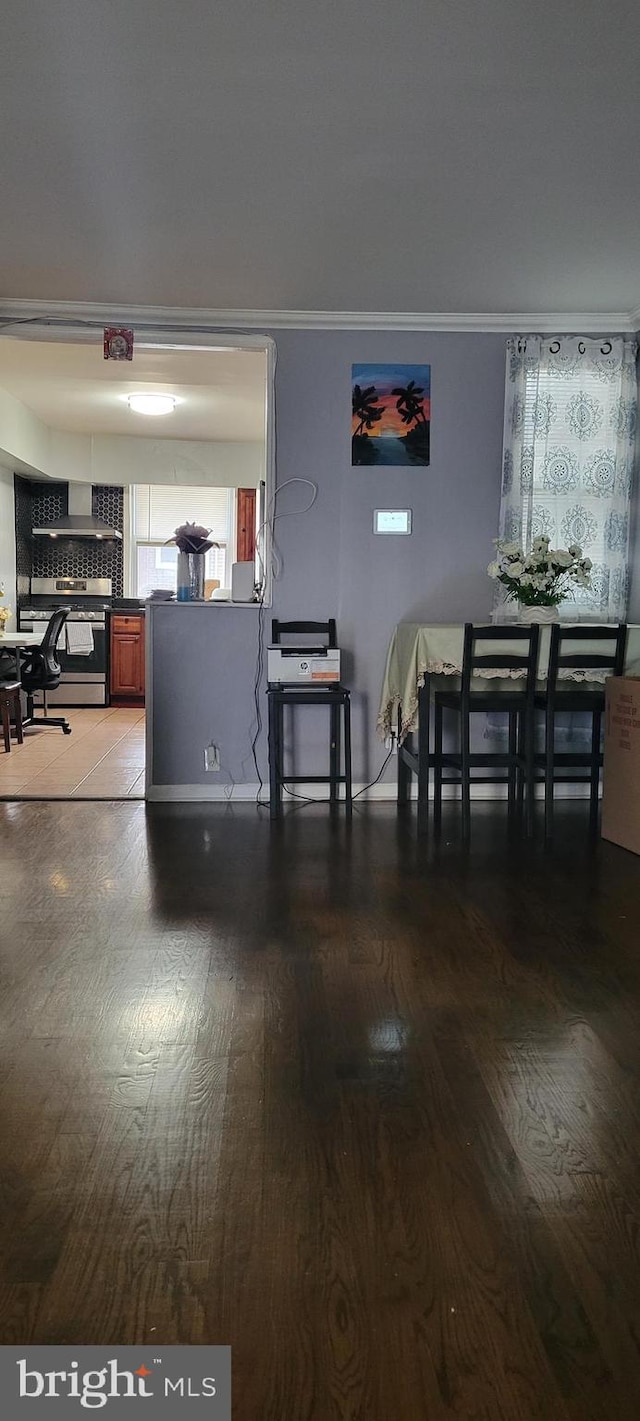 dining space with hardwood / wood-style floors and ornamental molding