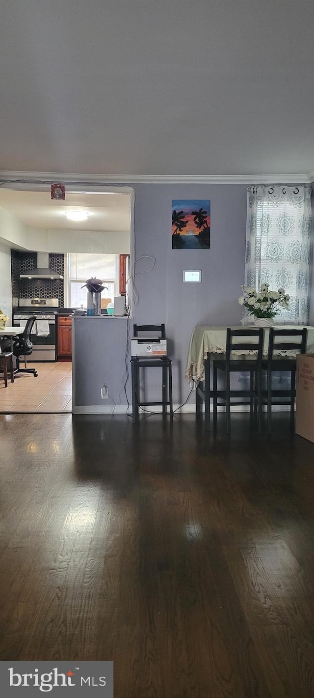 dining space with hardwood / wood-style flooring and ornamental molding