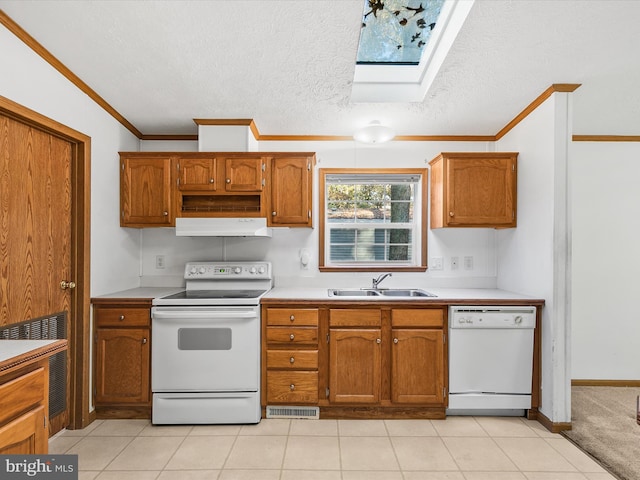 kitchen with a skylight, white appliances, a textured ceiling, sink, and light tile patterned floors