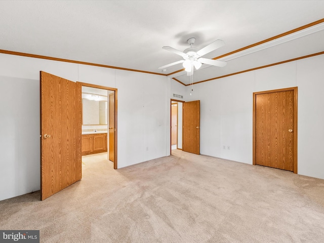 unfurnished bedroom with vaulted ceiling, ceiling fan, crown molding, and light colored carpet