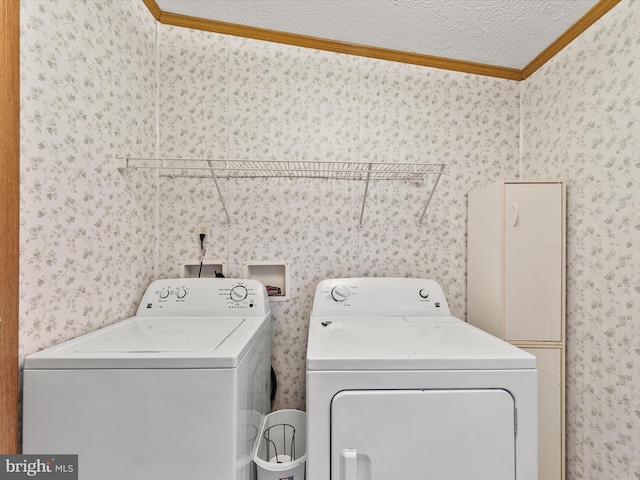 clothes washing area featuring washer and clothes dryer, crown molding, and a textured ceiling