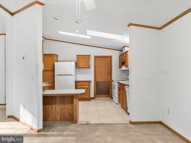 kitchen featuring vaulted ceiling with skylight, light colored carpet, and white appliances