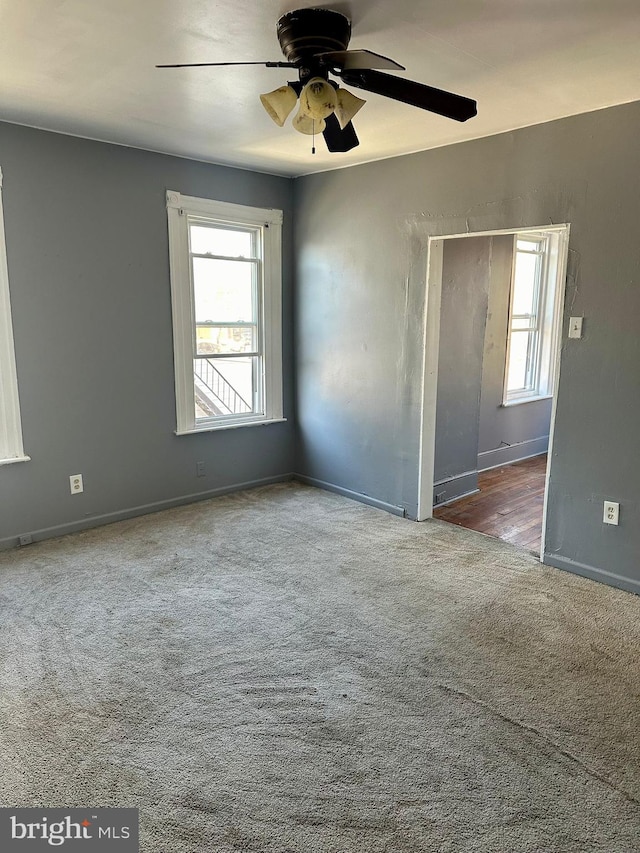 carpeted spare room with ceiling fan