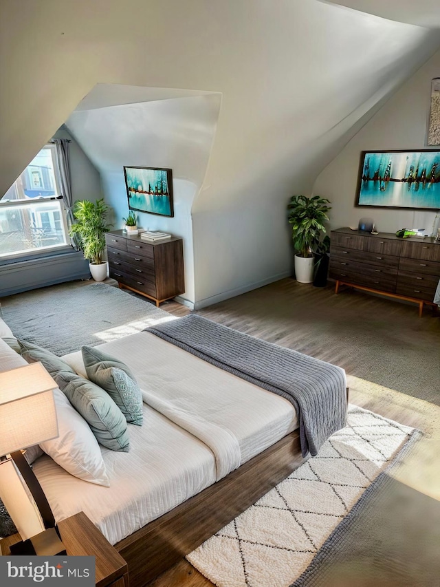 bedroom featuring light hardwood / wood-style floors and vaulted ceiling