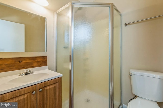 bathroom featuring walk in shower, vanity, and toilet