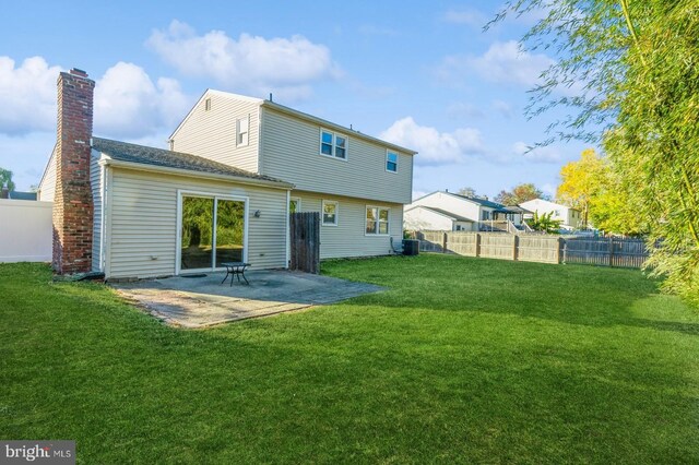 rear view of house featuring a patio, central AC, and a lawn