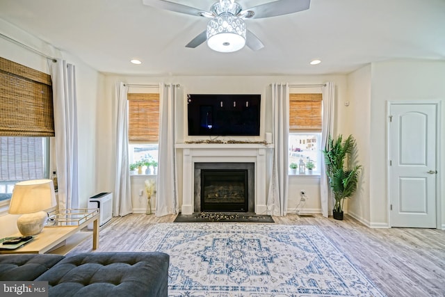 living room featuring light wood-type flooring, plenty of natural light, and ceiling fan