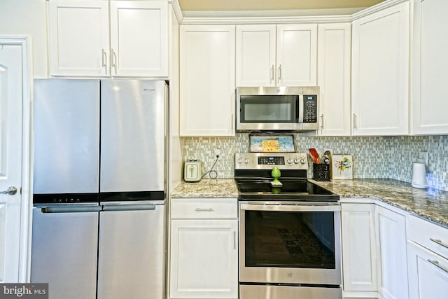 kitchen with white cabinets, light stone countertops, backsplash, and appliances with stainless steel finishes